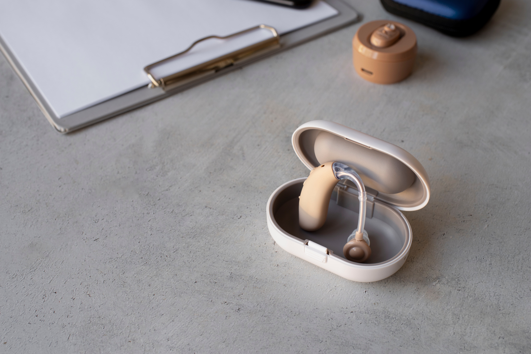 hearing aid in its open case on a desk