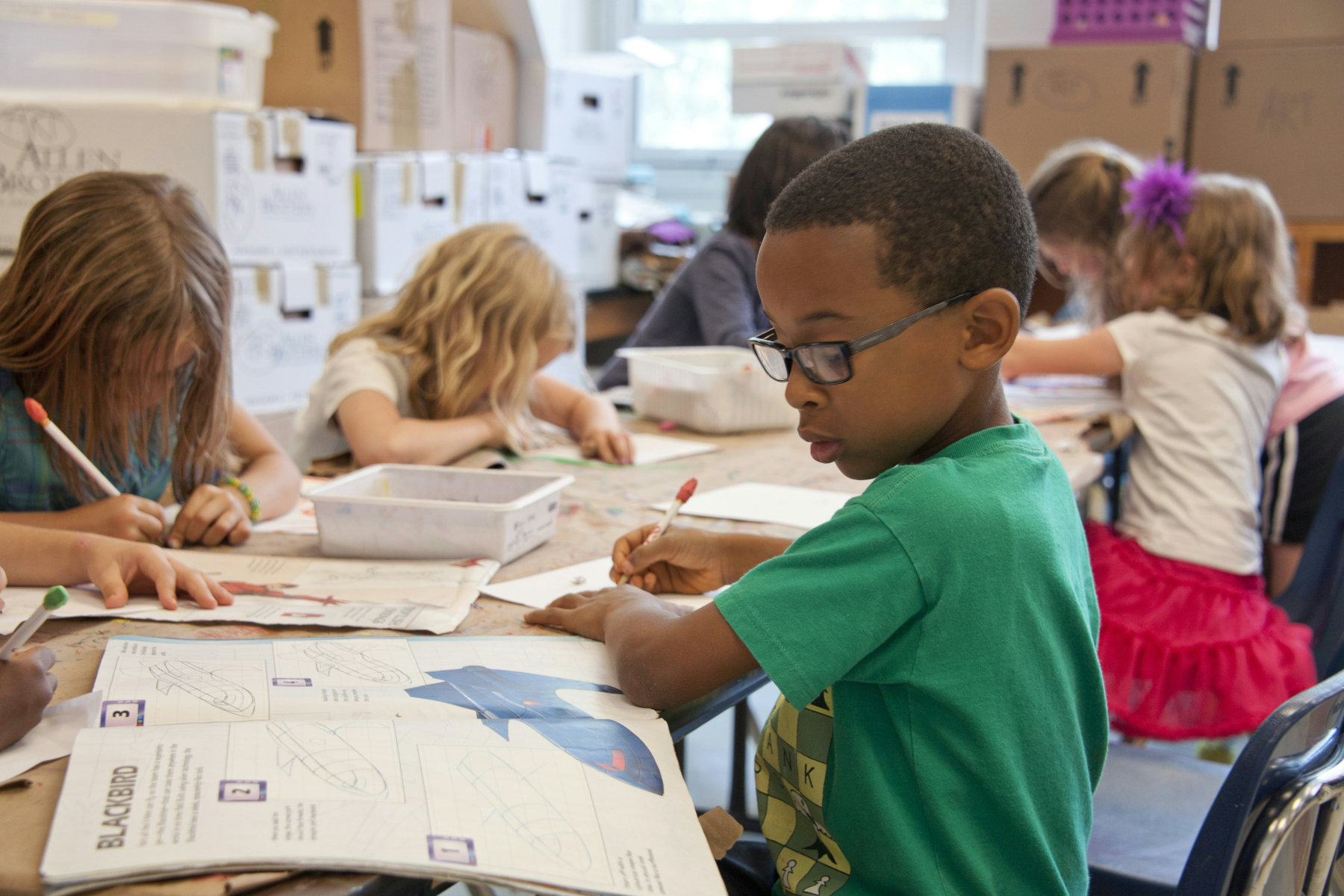 children writing in a classroom